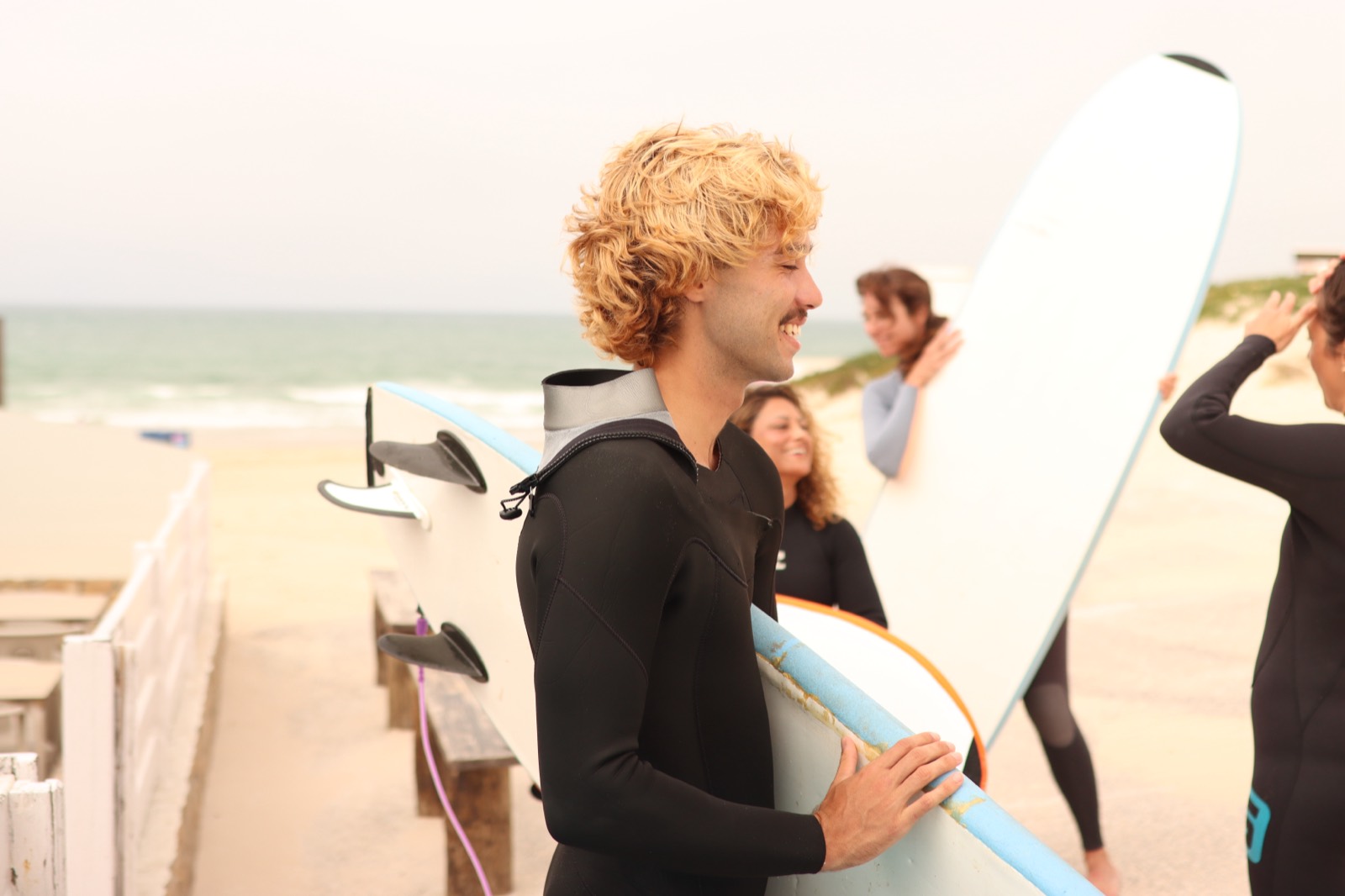 Coaches carrying boards and laughing outside the club in Baleal