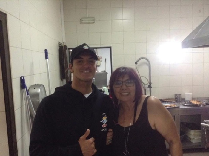 Gabriel Medina in a Rip Curl hoodie standing beside my aunt in the restaurant kitchen.