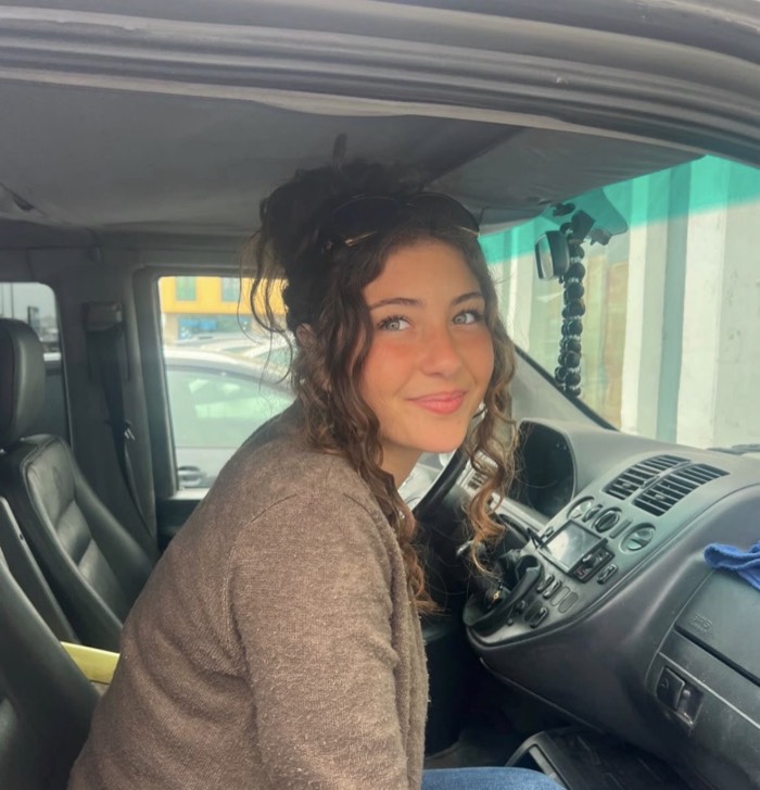 Carolina Caiado sitting in the driver’s seat of the club van, turning towards the camera.