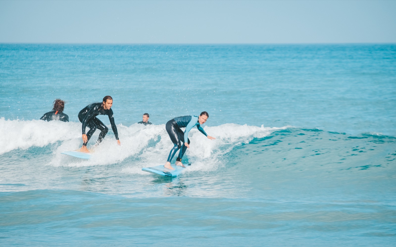 Students riding gentle whitewater in bright turquoise summer sea